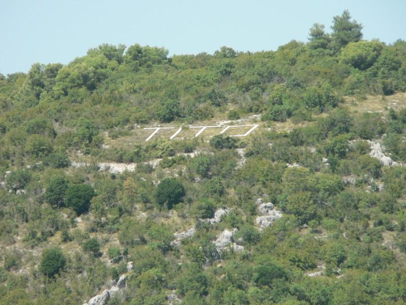 tito-felirat - Gyertekvelem TITO írás a mezőn